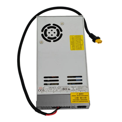 A silver metal power supply unit with a black cable and connector, featuring yellow warning labels and ventilation slots, photographed on a white background.