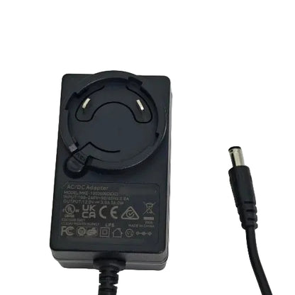 A black AC/DC power adapter with a circular plug and a black cable ending in a barrel connector, photographed on a plain light background.